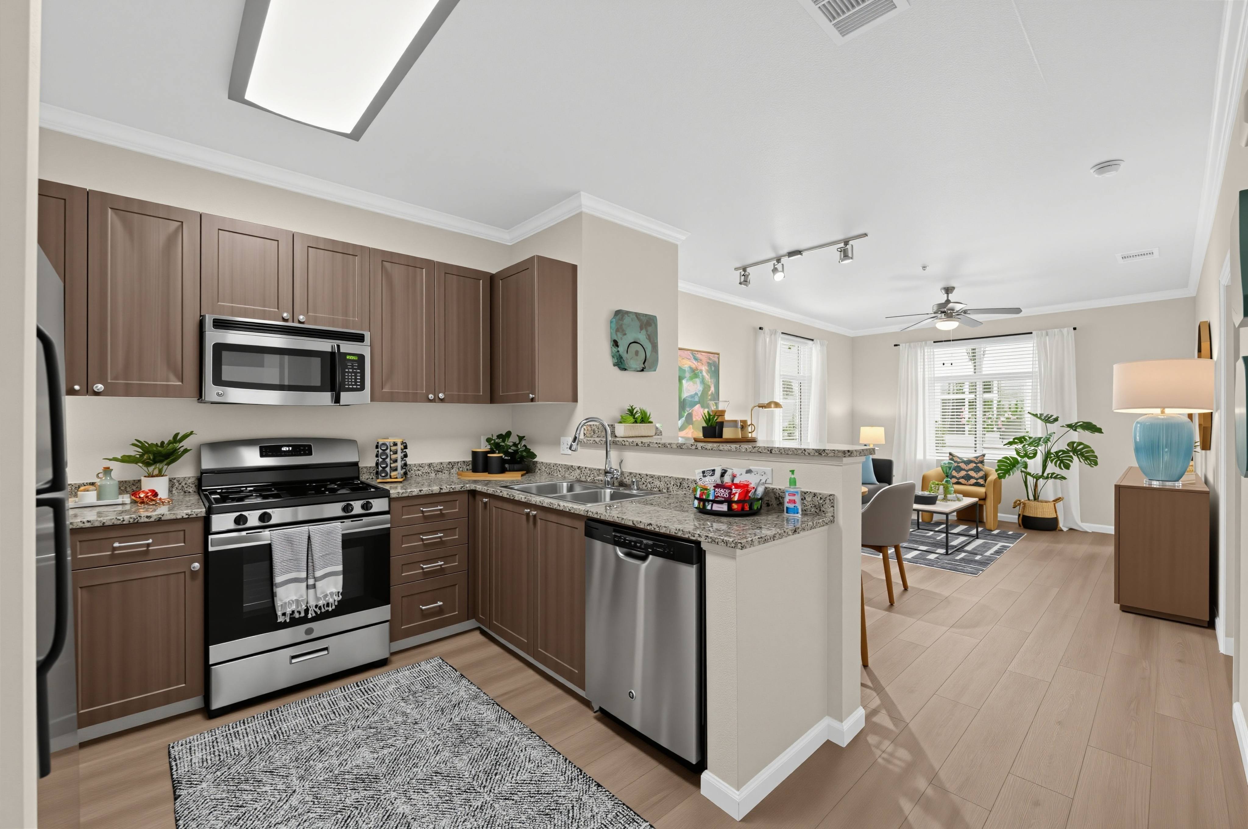 A modern kitchen with brown cabinets and stainless steel appliances.